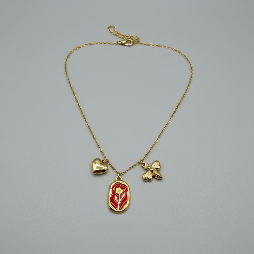 Collana Flora Aurea Rossa con tre charm dorati: cuore, piastra con rosa smaltata rossa e ape