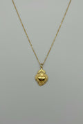 Collana con pendente Sacro Cuore in acciaio color oro antico con dettagli a rilievo, bordo decorato e fiamma, su catena sottile a maglia rolo dorata
