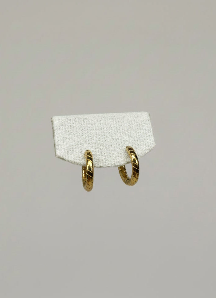 Orbis Tortus — orecchini a cerchio huggie con incisione a torsione diagonale 16mm in acciaio placcato oro, coppia
