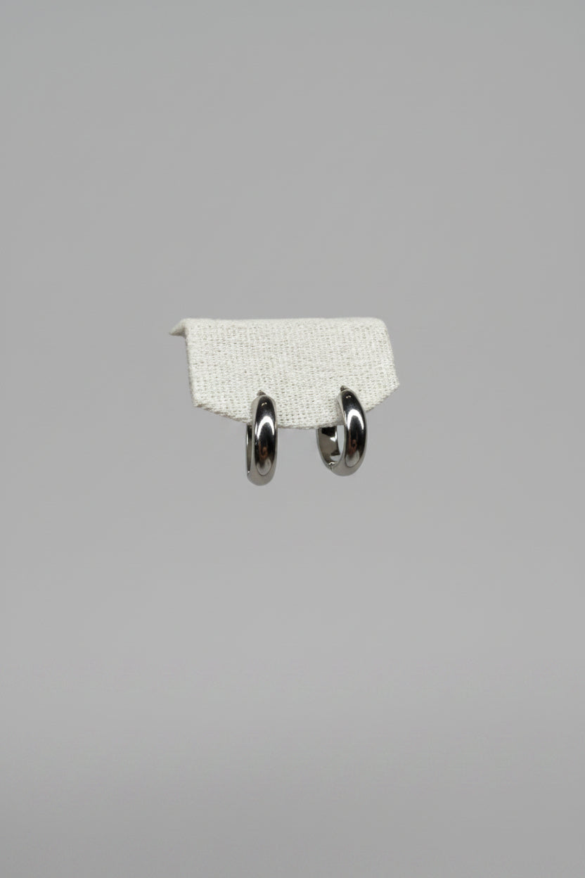 Luna Piena — orecchini a cerchio huggie bombato lucido 18mm in acciaio argento, coppia